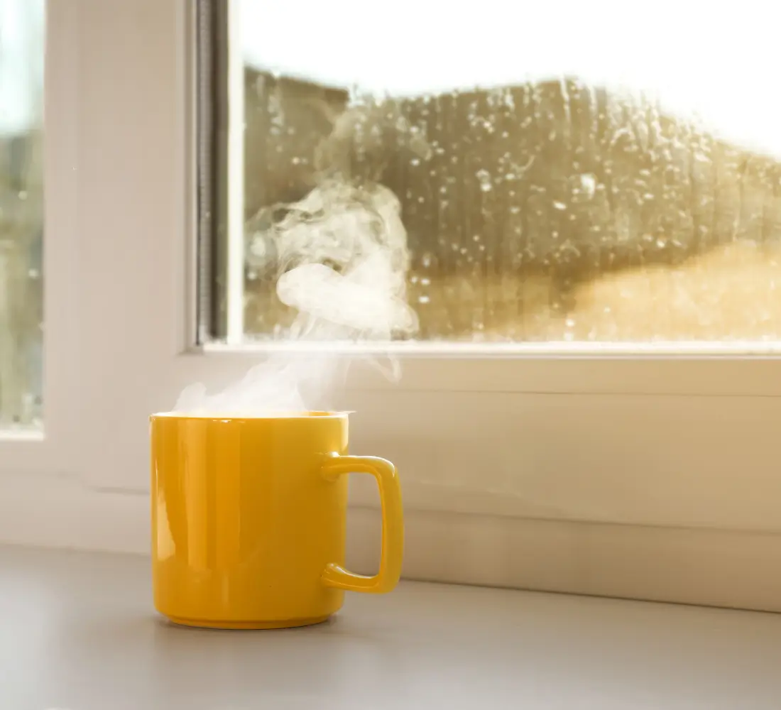 Cup of coffee beside a window on a sunny morning